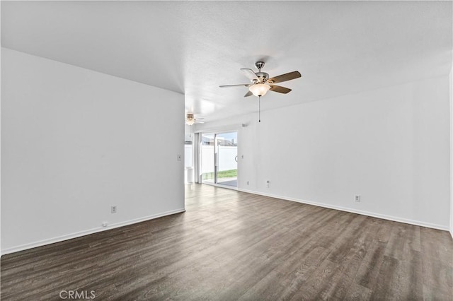 empty room with ceiling fan, a textured ceiling, baseboards, and dark wood-style flooring