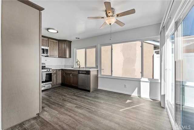 kitchen with a healthy amount of sunlight, appliances with stainless steel finishes, dark wood finished floors, and a sink