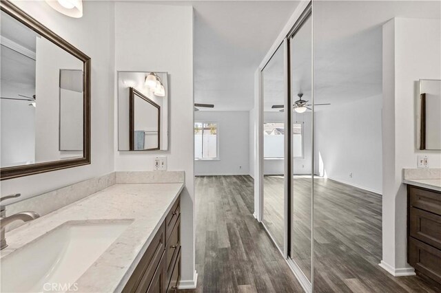 full bathroom featuring ceiling fan, vanity, and wood finished floors