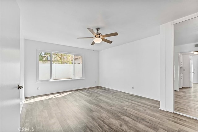 spare room with ceiling fan and wood finished floors