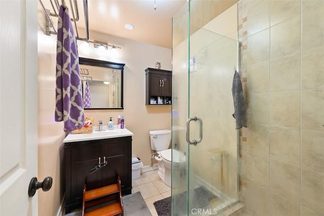 bathroom featuring vanity, tile patterned floors, toilet, and a stall shower