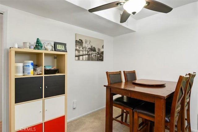 carpeted dining room featuring baseboards and a ceiling fan