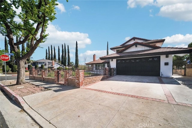 view of front of home featuring a fenced front yard, stucco siding, a gate, a garage, and driveway