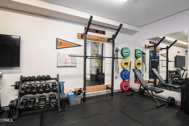 workout area with a garage and strapped water heater