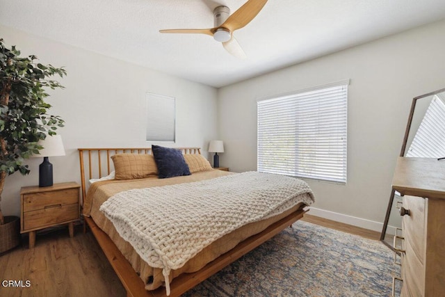 bedroom with ceiling fan, baseboards, and wood finished floors