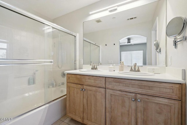 bathroom featuring visible vents, a sink, combined bath / shower with glass door, and tile patterned floors