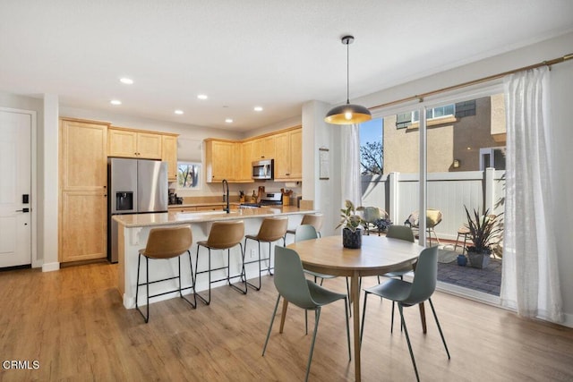 dining space featuring light wood-style flooring and recessed lighting