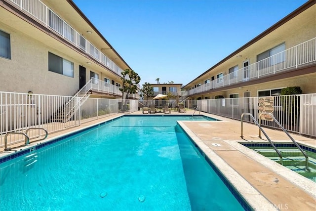 pool featuring fence and a patio