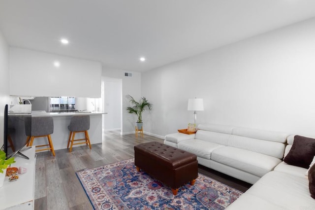 living room featuring recessed lighting, visible vents, baseboards, and wood finished floors