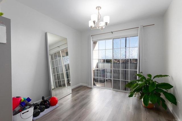 dining area with baseboards, an inviting chandelier, and wood finished floors