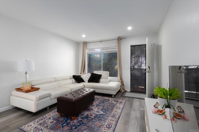 living room with recessed lighting, baseboards, and wood finished floors