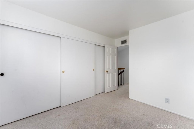 unfurnished bedroom with carpet, a closet, and visible vents