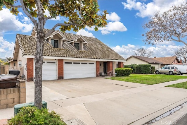 view of front of house featuring a garage, brick siding, a tiled roof, concrete driveway, and a front yard