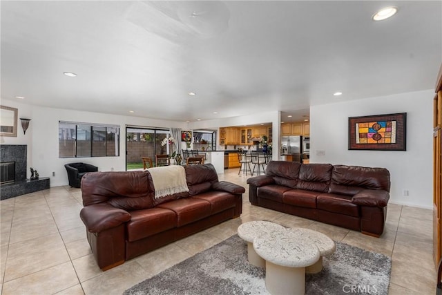 living area featuring light tile patterned flooring, a high end fireplace, and recessed lighting