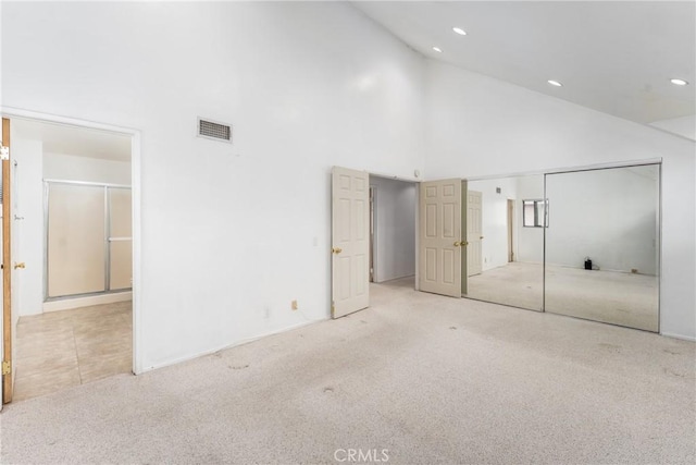 unfurnished bedroom with high vaulted ceiling, carpet, visible vents, and recessed lighting