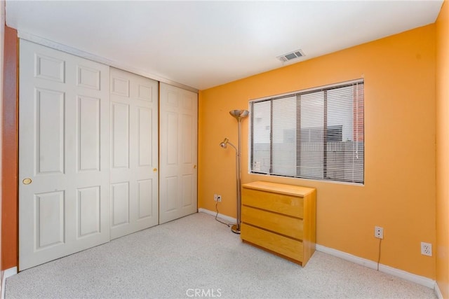 unfurnished bedroom with baseboards, a closet, visible vents, and light colored carpet