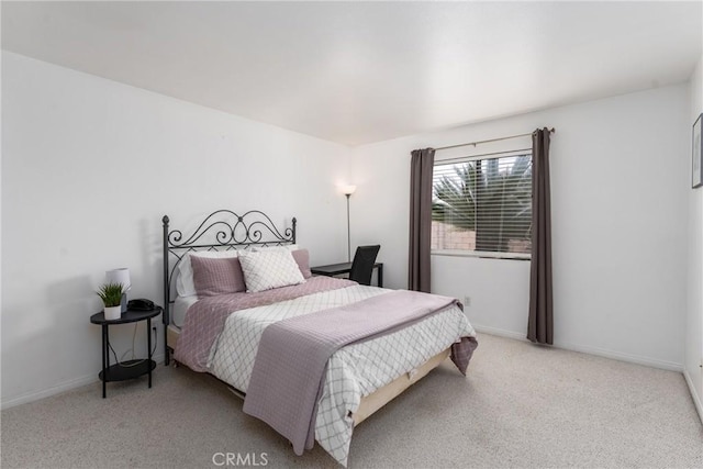 bedroom featuring light carpet and baseboards