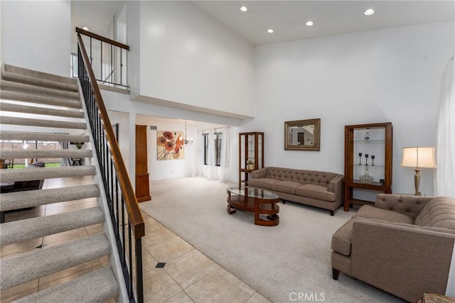 living room with a high ceiling, stairway, carpet, and recessed lighting