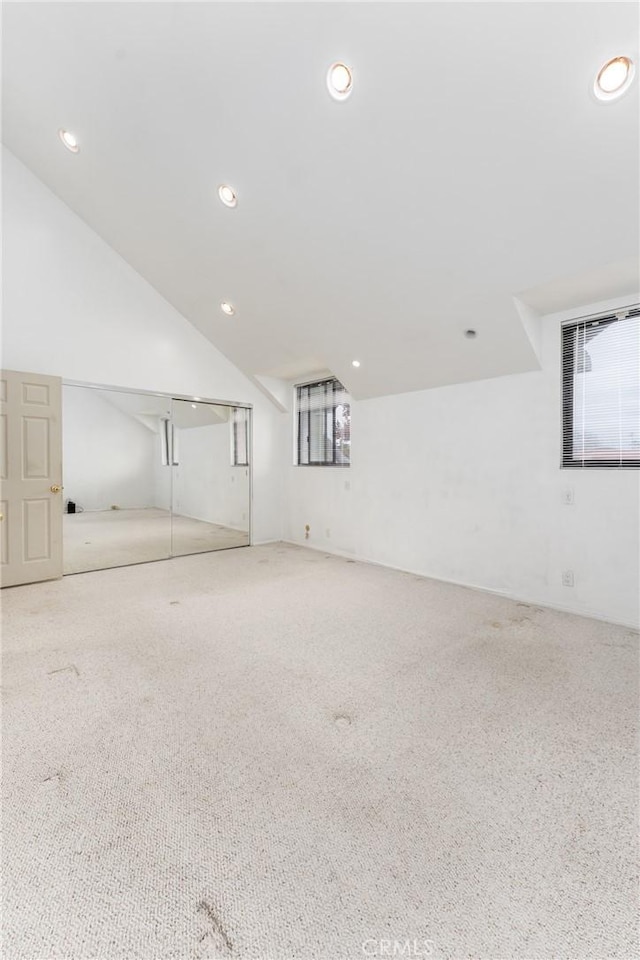 carpeted empty room with recessed lighting and vaulted ceiling