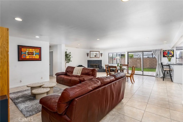 living room featuring recessed lighting, a fireplace, baseboards, and light tile patterned floors