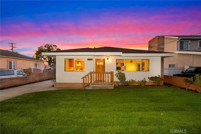 view of front of house with concrete driveway, a front lawn, and fence