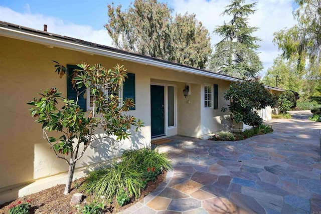 view of exterior entry featuring stucco siding