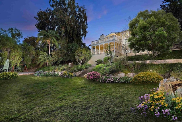 view of yard featuring stairway and a balcony