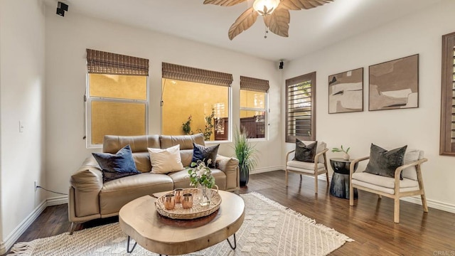 living room featuring baseboards, a ceiling fan, and wood finished floors