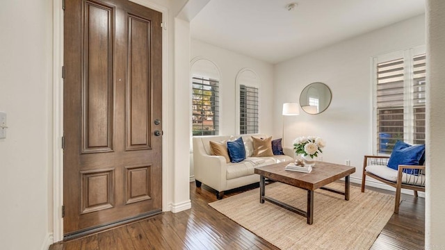 living area featuring dark wood-type flooring and baseboards