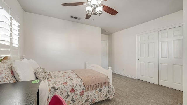 carpeted bedroom with baseboards, visible vents, a closet, and ceiling fan