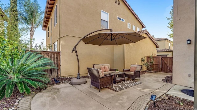 view of patio / terrace with an outdoor living space, a gate, and fence