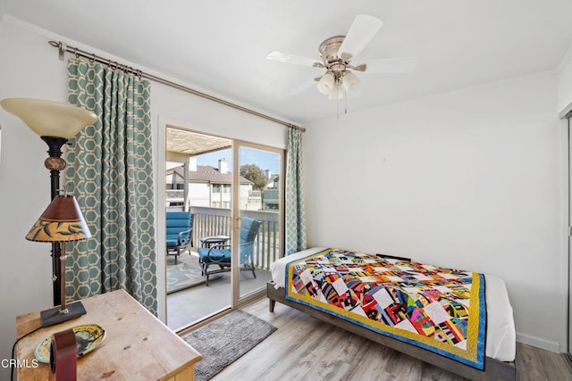 bedroom with crown molding, a ceiling fan, wood finished floors, access to outside, and baseboards