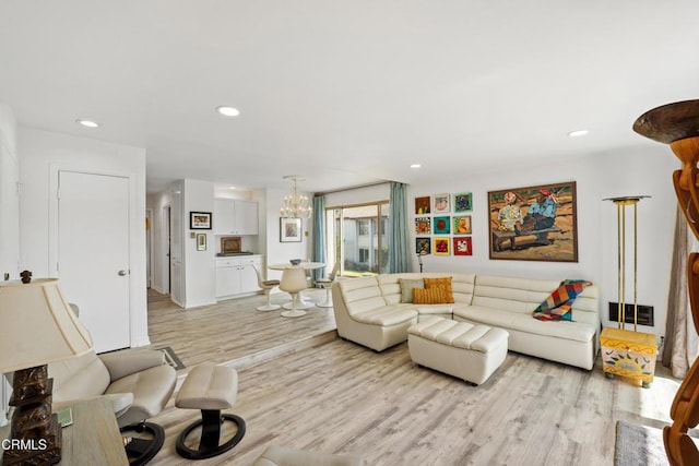 living area featuring light wood finished floors, a chandelier, and recessed lighting