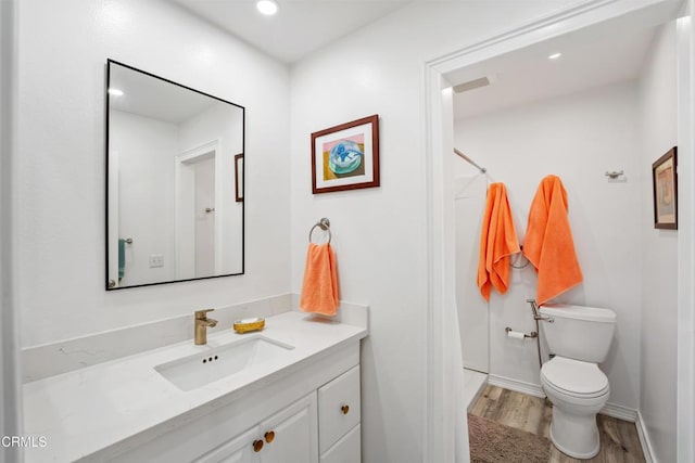 bathroom with toilet, a shower with curtain, wood finished floors, and vanity