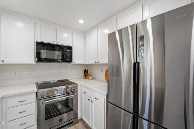 kitchen featuring stainless steel appliances, light countertops, white cabinetry, and decorative backsplash