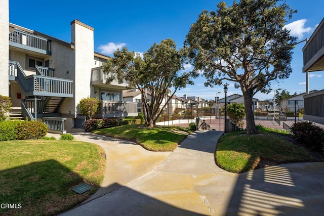 view of home's community with a yard, fence, and a residential view