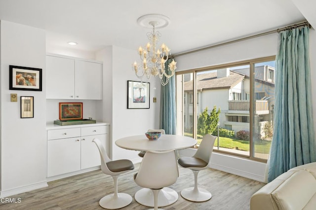 dining room featuring baseboards, light wood-style flooring, and a healthy amount of sunlight