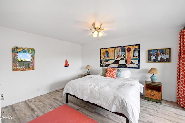 bedroom featuring a ceiling fan, baseboards, and wood finished floors