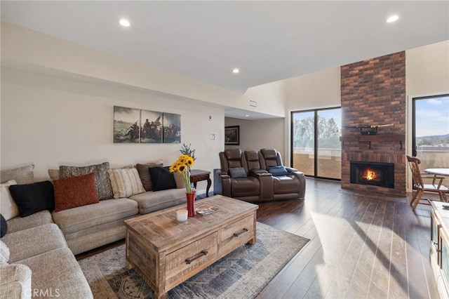 living area featuring recessed lighting, a brick fireplace, and wood finished floors