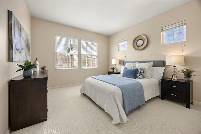 bedroom with light carpet and baseboards