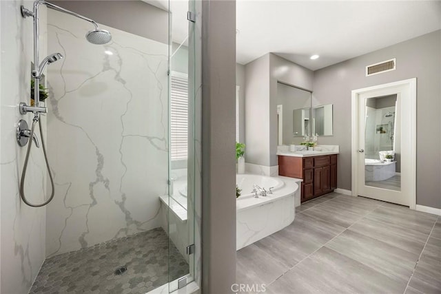 bathroom with a bath, vanity, a marble finish shower, and visible vents