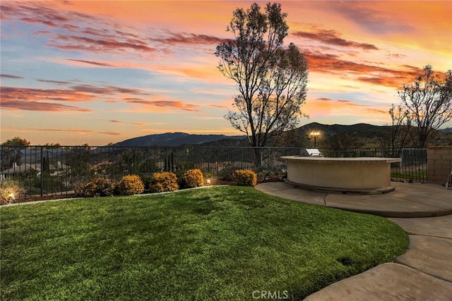 yard at dusk with fence and a mountain view