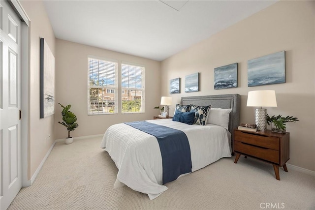 bedroom featuring light carpet and baseboards