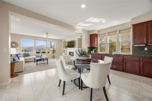 dining area featuring recessed lighting, baseboards, and a glass covered fireplace