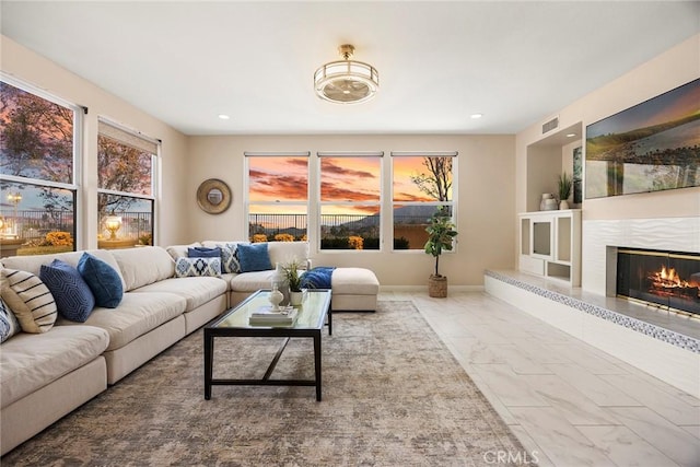 living area featuring marble finish floor, a fireplace, recessed lighting, visible vents, and baseboards