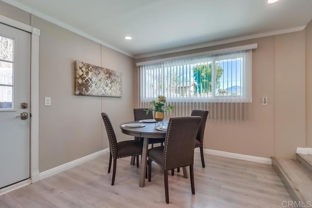 dining room featuring recessed lighting, baseboards, crown molding, and light wood finished floors