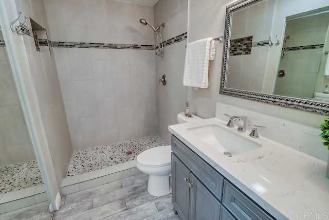 full bath with vanity, a shower stall, and toilet