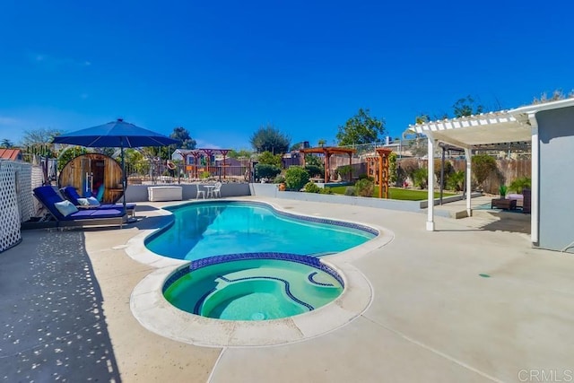 view of swimming pool with a pool with connected hot tub, fence, a pergola, and a patio