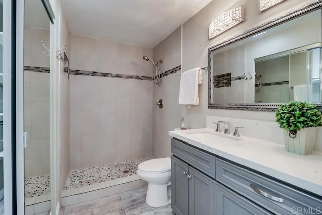 full bath with a stall shower, vanity, and toilet