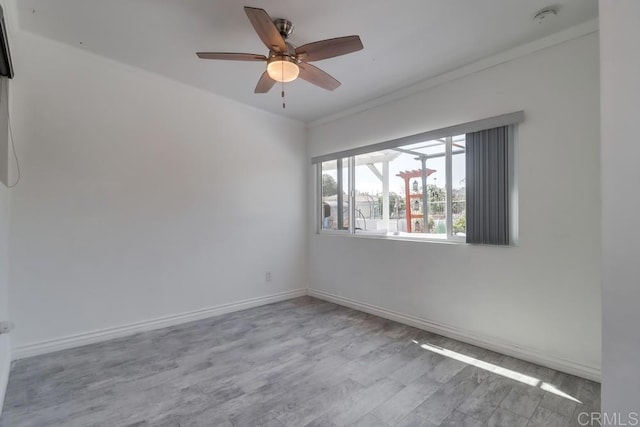 unfurnished room with ornamental molding, ceiling fan, baseboards, and wood finished floors